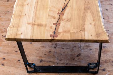 Tischplatte aus altem Holz mit einemdekorativ verschlossenem Riss