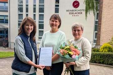 drei Frauen halten eine Urkunde hoch ( v.l. Irene Schmidt (Saale-Unstrut Tourismus GmbH), Sandra Engel (Weinberghotel Edelacker), Antje Peiser (Saale-Unstrut Tourismus GmbH))