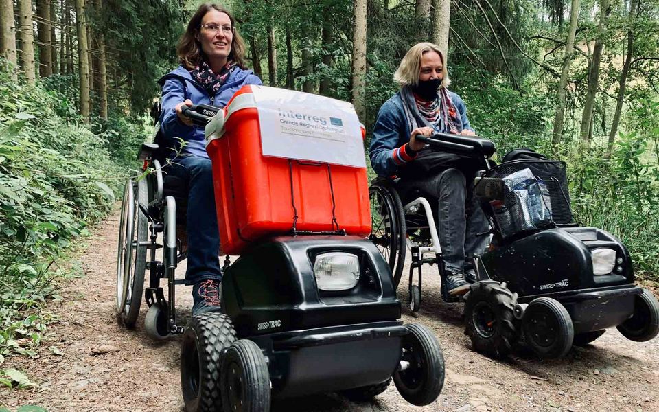 Mit den Rollstuhlzuggeräten lassen sich im Naturpark Südeifel auch unebene Waldwege meistern. Foto: Naturpark Südeifel, Ansgar Dondelinger