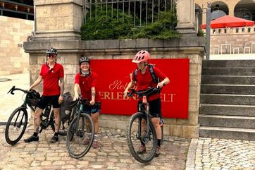 Drei Frauen mir Fahrrädern freuen sich auf den Start des Rad-Events "Stößchen on Tour" an der Rotkäppchen Erlebniswelt